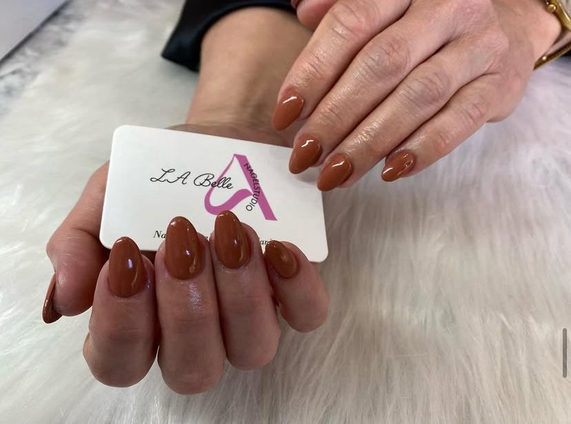 Witte nagels met kleine rode hartjes op een roze achtergrond