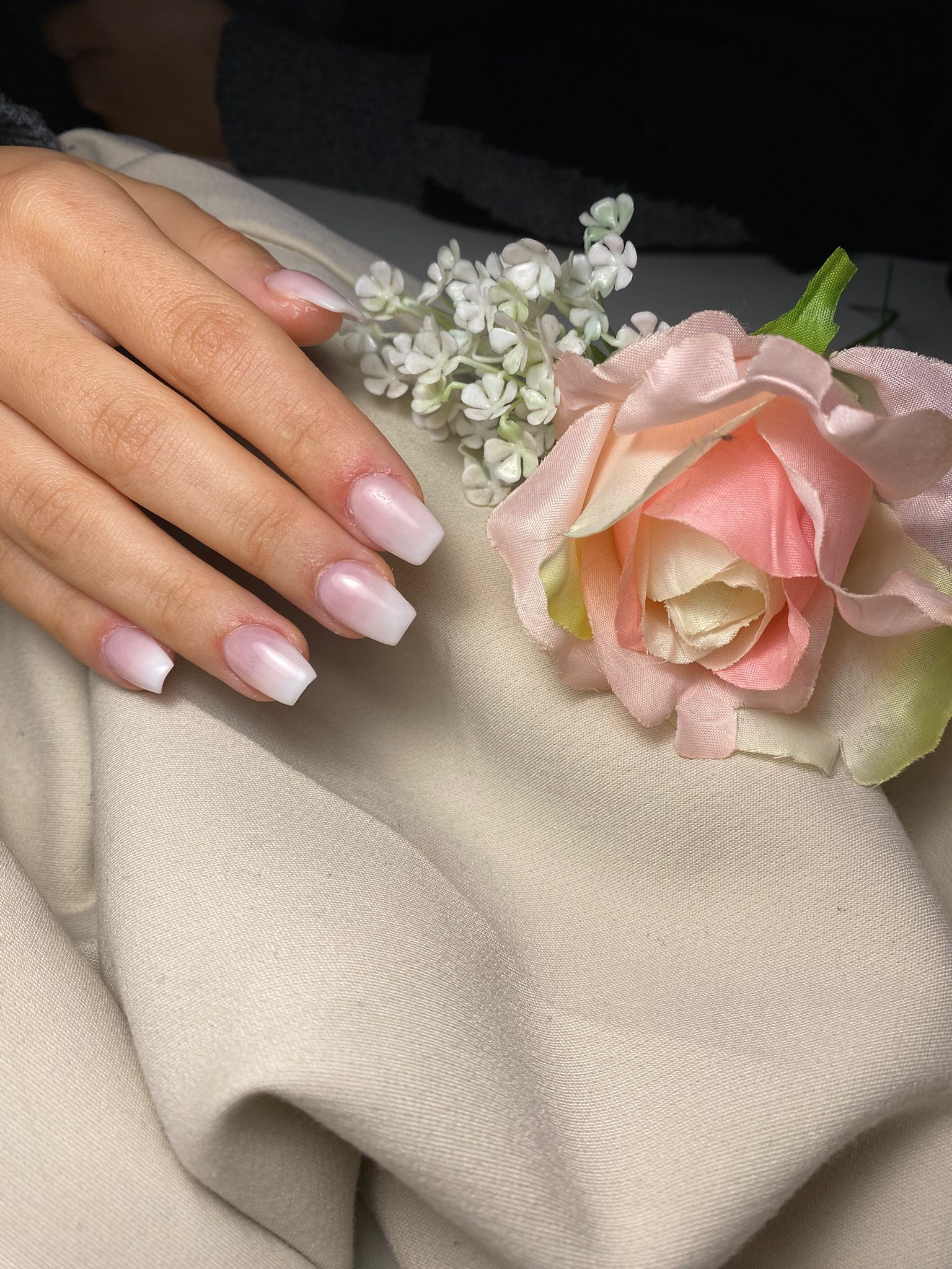 Zwarte en roze nagels met een roze donut met sprinkles